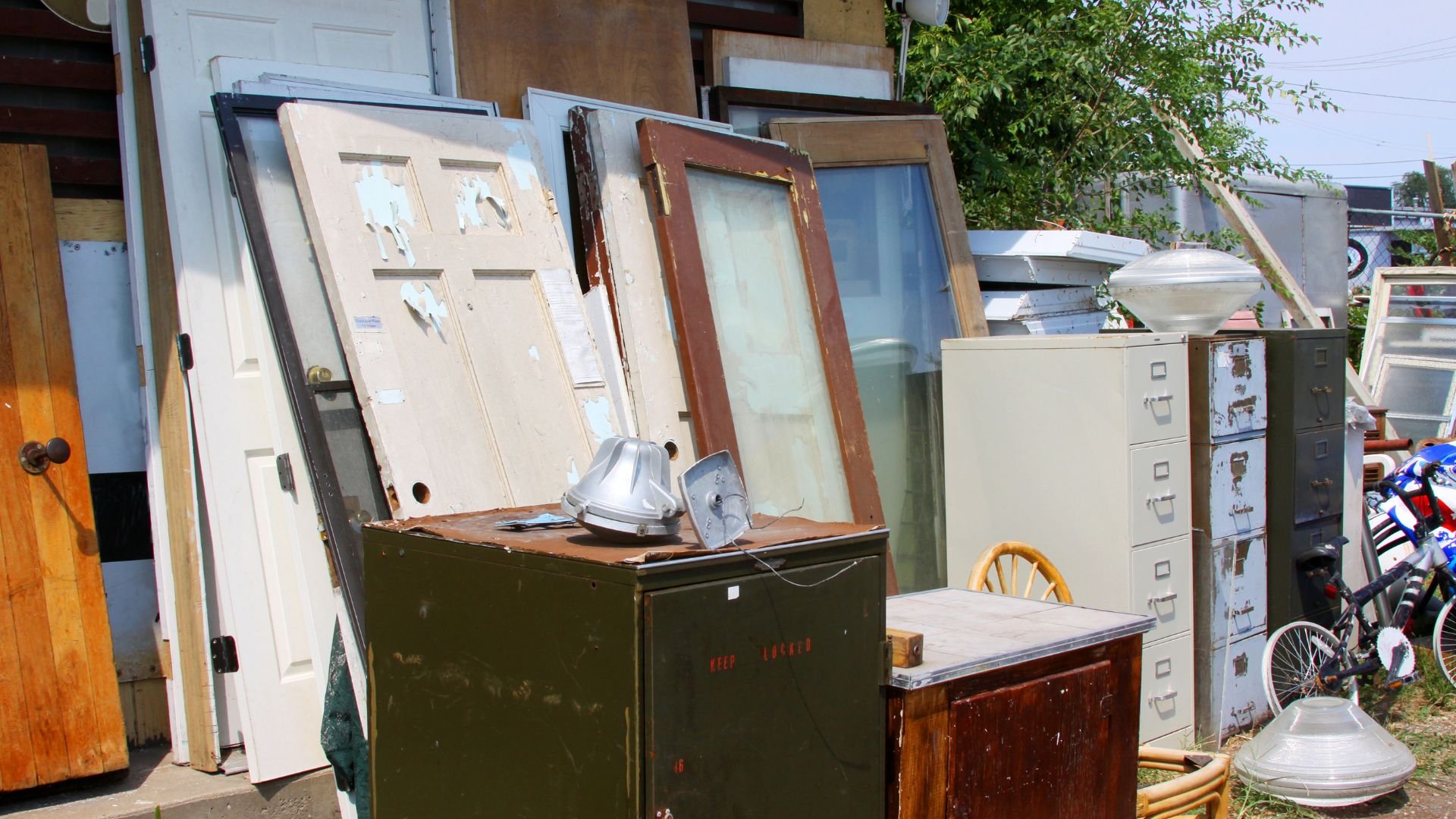 Junkyard scene with old doors, filing cabinets, and vintage lighting fixtures